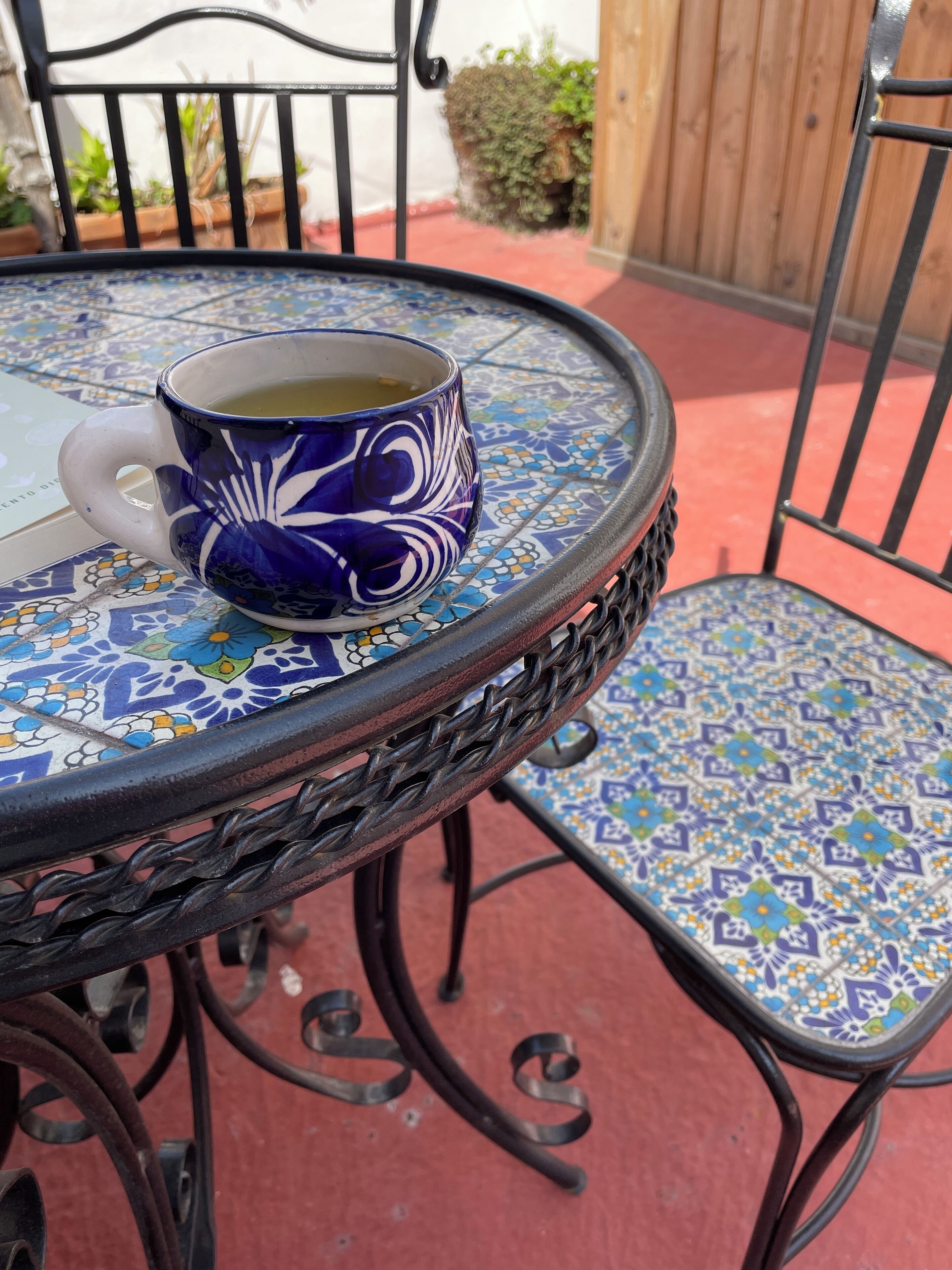 A table with a blue and white patterned mug and a matching chair.