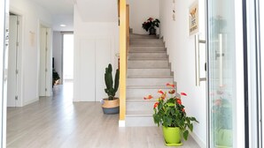 Een modern interieur met een trap, een potplant en een bord aan de muur.