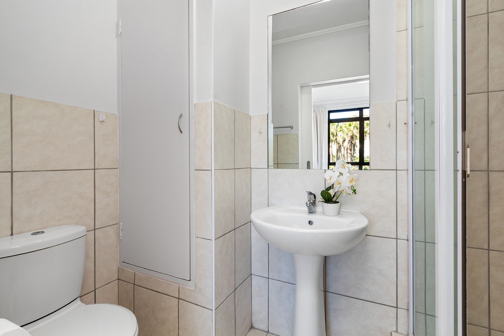 Un baño con inodoro, lavabo y ducha.