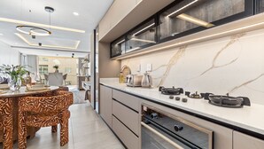 Et moderne køkken med marmor bordplade, indbygget ovn og moderne design.
