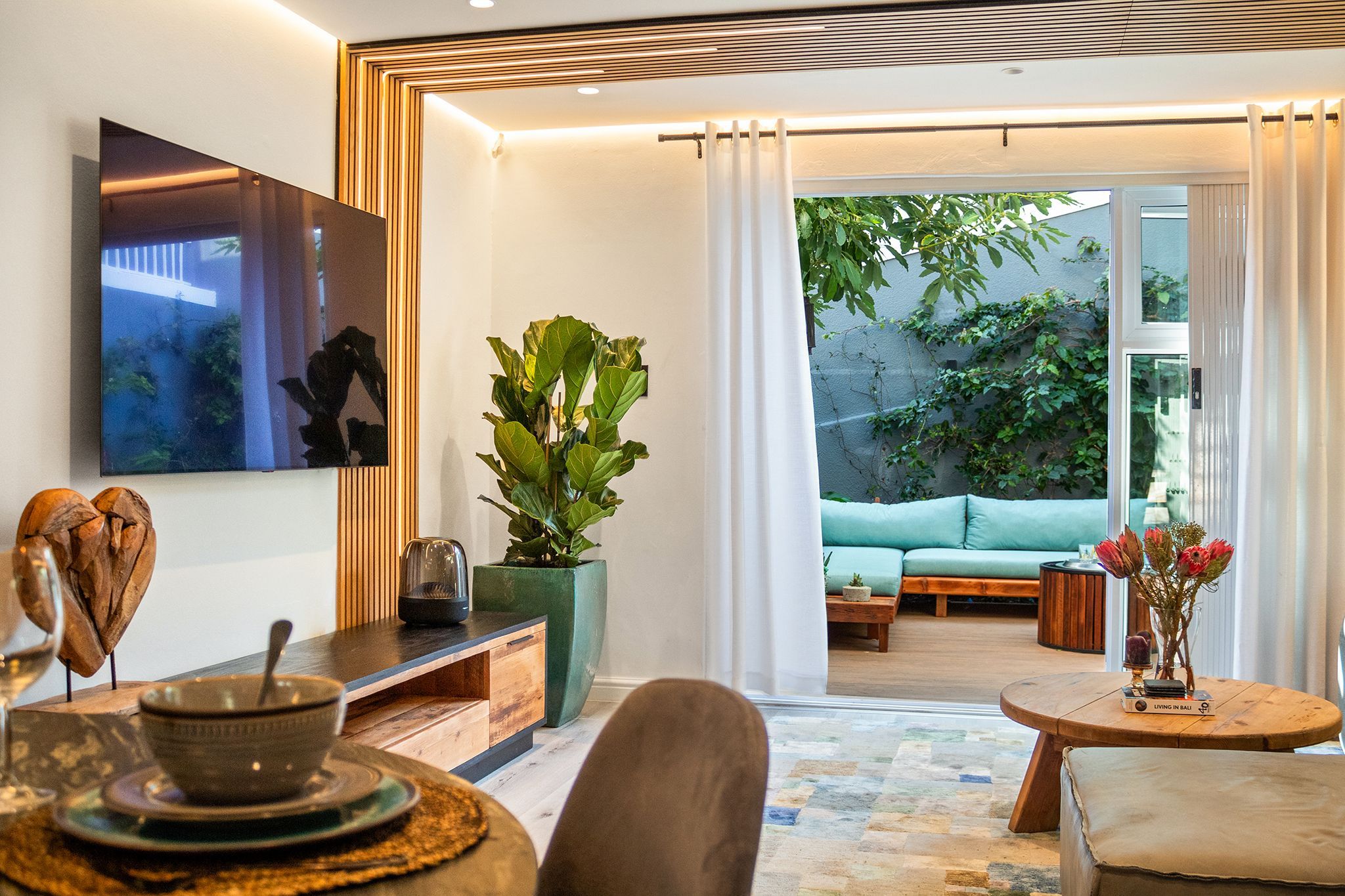Una sala moderna con un sofá, una mesa de centro y un comedor con una mesa y sillas.