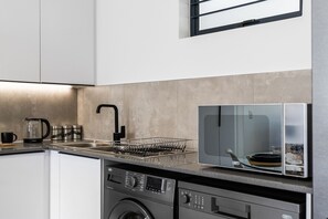 A modern kitchen with a dishwasher, washing machine, and a microwave. - Mandalay Hideaway (Johannesburg)