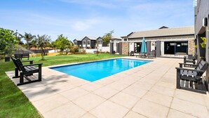 Ein Wohngebiet mit Schwimmbad, Außenbereich und einem Haus mit Steinverkleidung.