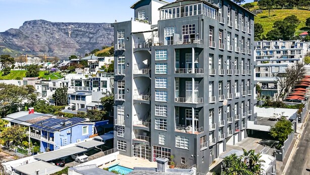 A multi-story hotel with balconies, a pool, and a view of a mountainous landscape. - Harbour Terrace 7 (Cape Town)