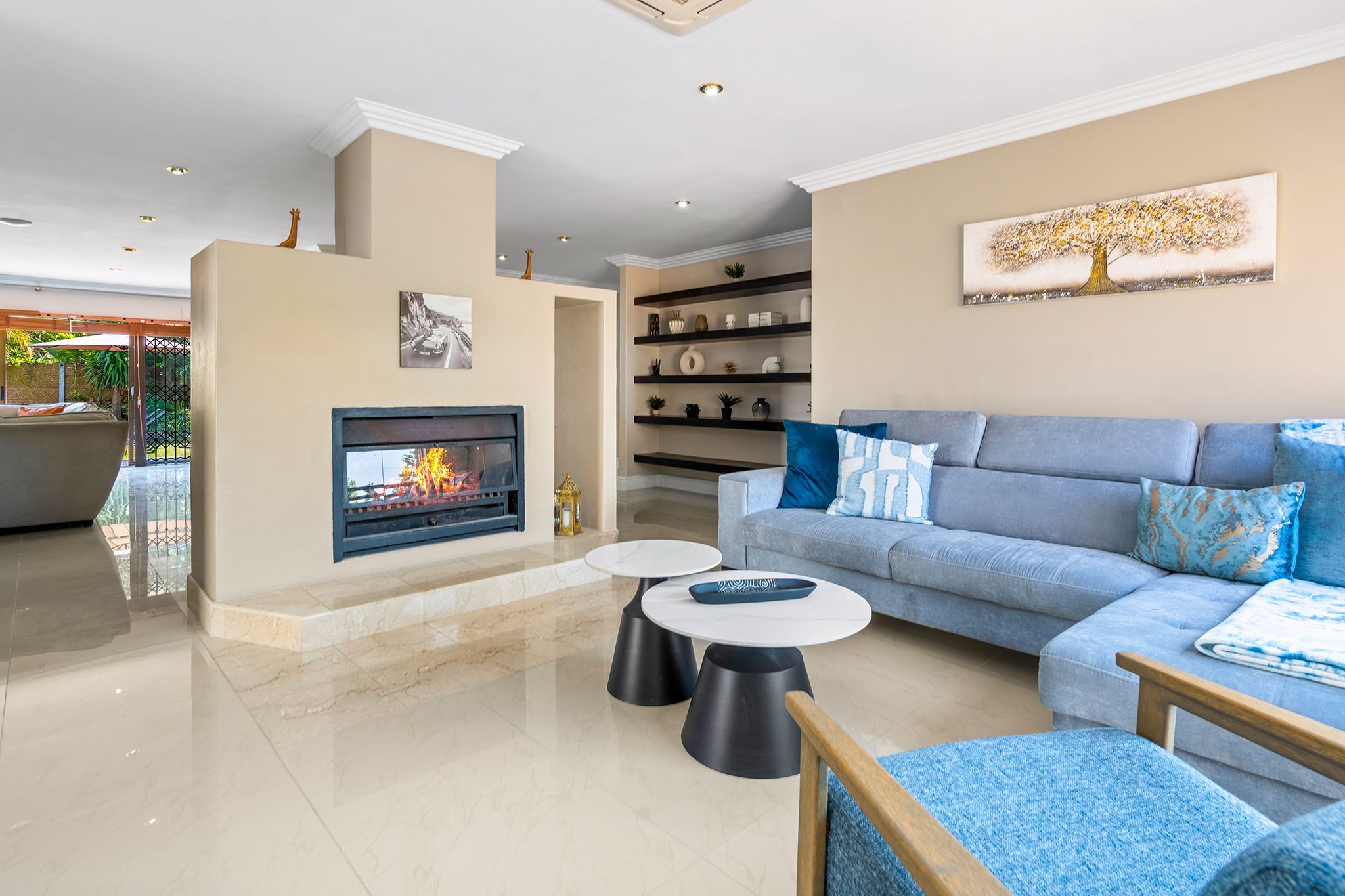 Un salon moderne avec une cheminée, un ensemble de canapés et une table basse.