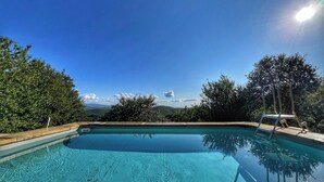 A clear blue swimming pool with a wooden deck and metal ladder, surrounded by trees and a clear sky. - La Fonte - Two Bedroom House, Sleeps 4 (Subbiano)