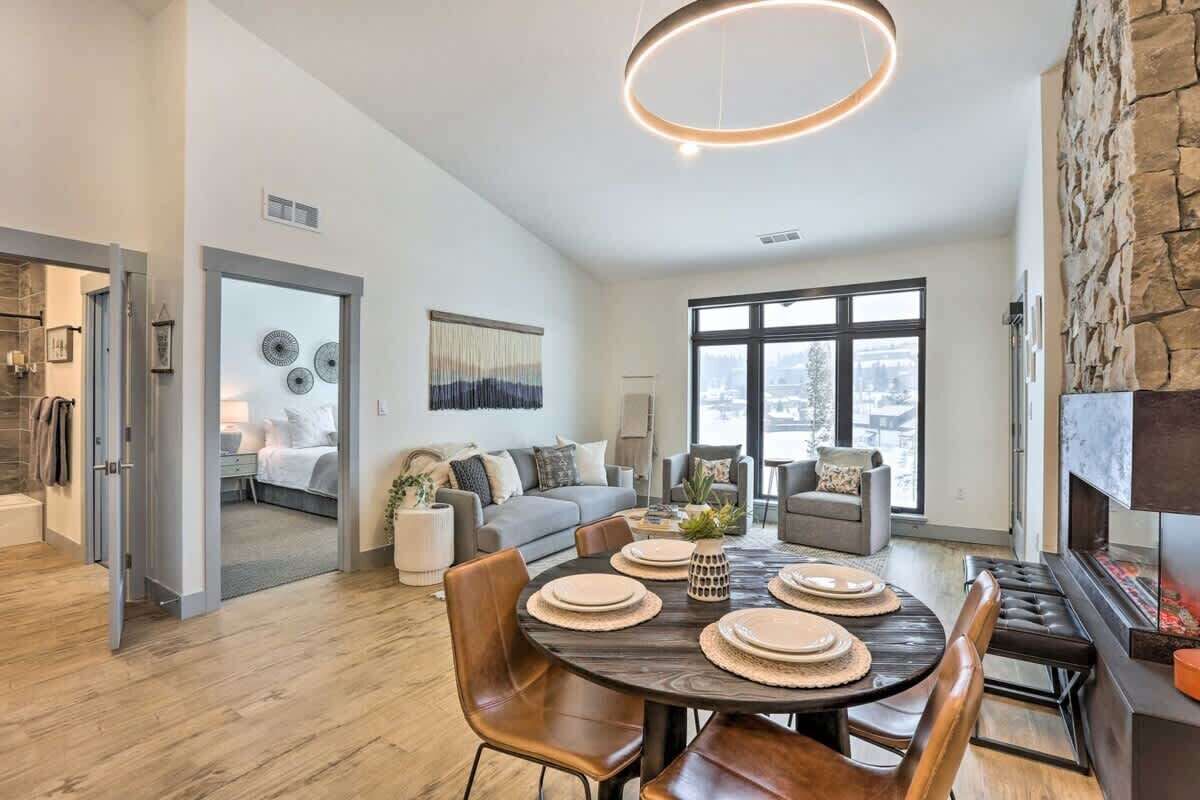 Una sala de estar moderna con comedor, ventanas amplias y una pared de acento de piedra.