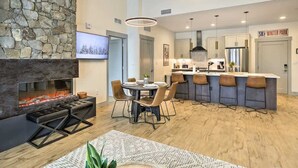 Una cocina moderna con pared de piedra, chimenea y barra.