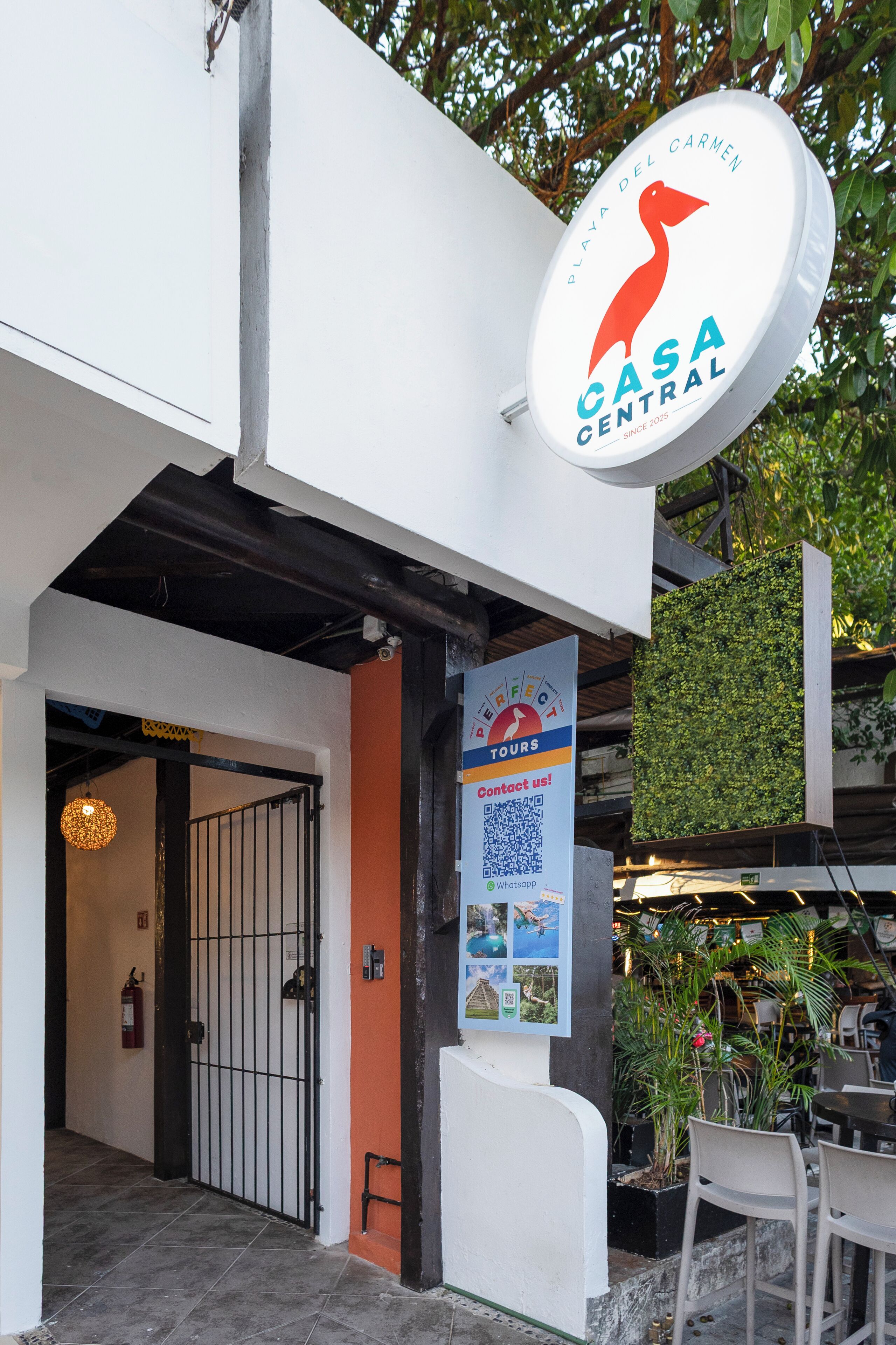 A building with a sign reading "Casa Central" and a "Perfect Tours" sign with a QR code.