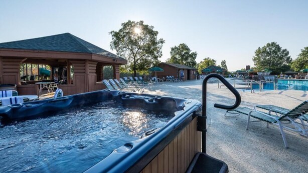 A hot tub area with lounge chairs and a poolside setting. - Westgate Branson Woods NYE 2Bedroom Villa. (Branson)