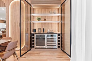 Una cocina moderna con armarios de madera, horno integrado y comedor con mesa y sillas.