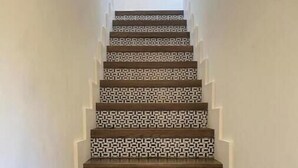 Eine Treppe mit einem geometrischen Muster auf den Stufen und weißen Wänden.