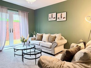 A living room with a sofa, a glass coffee table, and a potted plant. - Toast Stays - Dene Edge (Lanchester)
