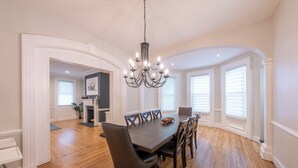 A dining area with a dark wooden table, black chairs, and a chandelier. - Casa Francesca 6BR Villa & Heated Pool (Roselle)