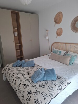A bedroom with a bed, a wardrobe, and wall decor. - Quiet Apartment Near the Beaches – Relaxation Guaranteed with Air Conditioning (Six-Fours-les-Plages)