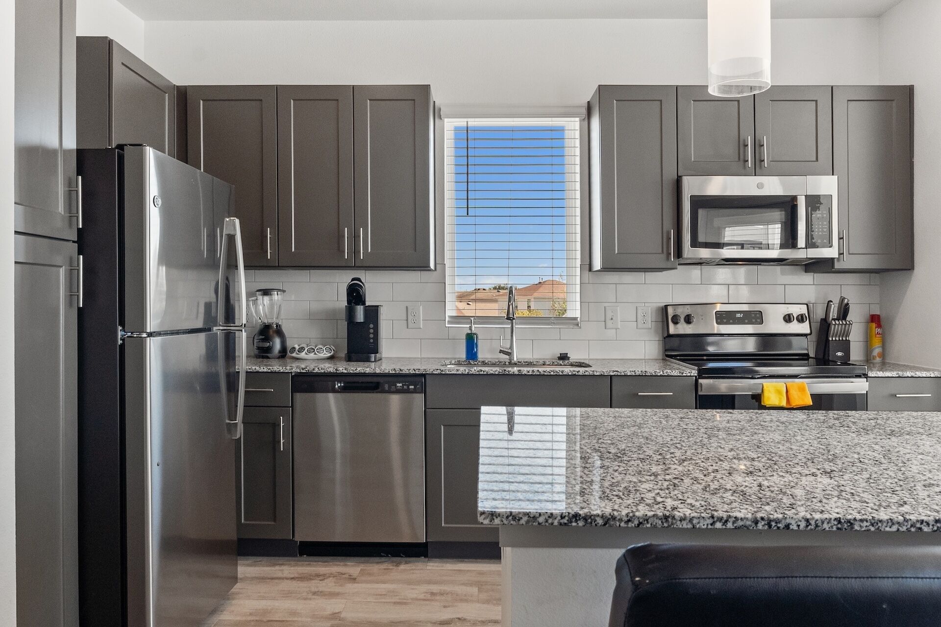 A modern kitchen with stainless steel appliances, a dishwasher, and a granite countertop.