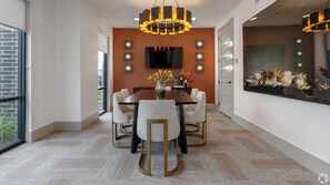 A modern dining area with a large table, four chairs, a chandelier, and a flat-screen TV mounted on the wall. - Luxury 2BD/2BA Next to Airport kkc7 (Del Valle)