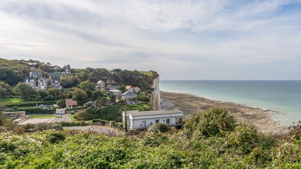 A coastal town with houses on a cliff overlooking the sea.