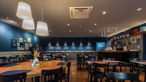 A restaurant with round tables, black chairs, and pendant lighting. - Modern, well located in Sampa next to the Faria Lima subway station (São Paulo)