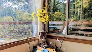 Una stanza accogliente con una panca di legno, una statua di Buddha, un bollitore e un vassoio con due tazze.