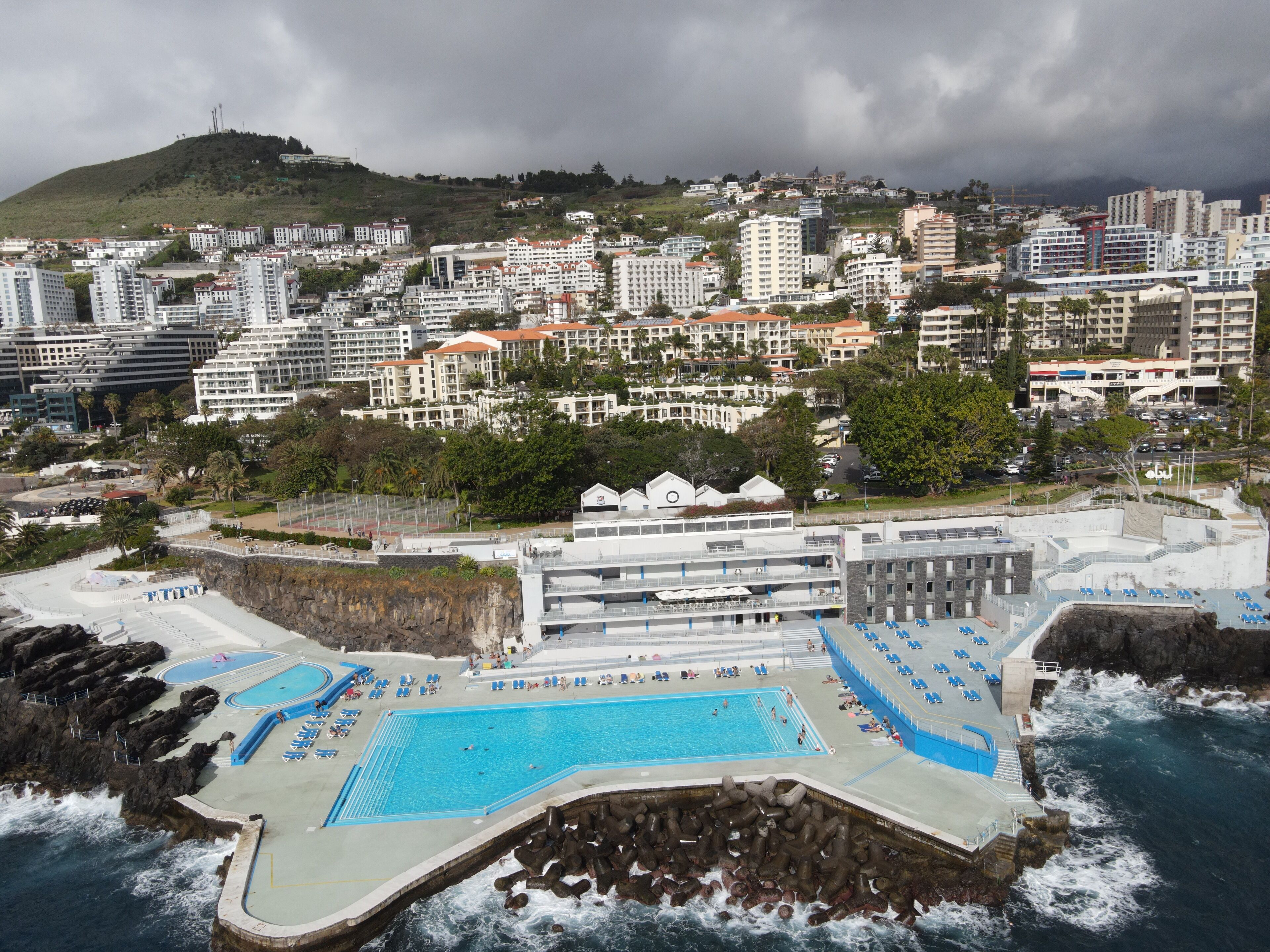 Playa en los alrededores, playa de arena negra, camastros y sombrillas 