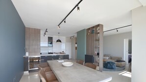 Una cocina moderna con una isla central, electrodomésticos integrados e iluminación colgante.
