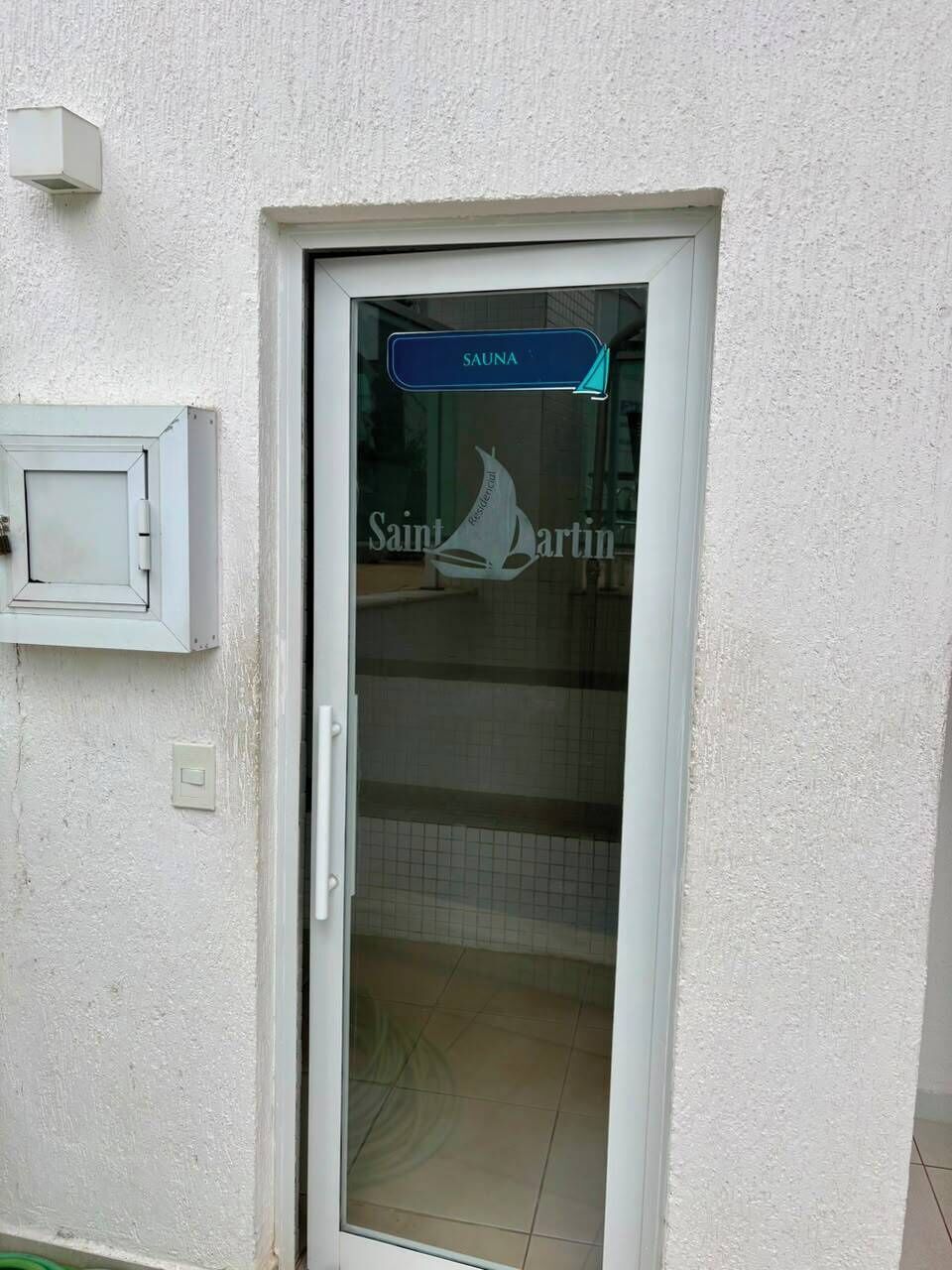 A door with a sign reading 'SAUNA' and a logo for 'Saint Martin' on the glass.