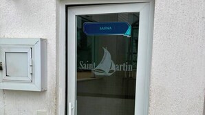 A door with a sign reading 'SAUNA' and a logo for 'Saint Martin' on the glass.