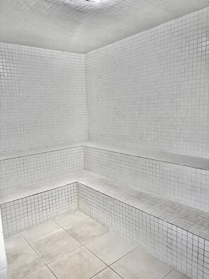 A tiled shower area with a corner design, a tiled floor, and a ceiling with a grid pattern. - Apartment with full leisure facilities, air conditioning in the rooms and Wi-Fi (Ubatuba)