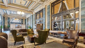 A lobby with leather armchairs, a coffee table, and a reception desk.