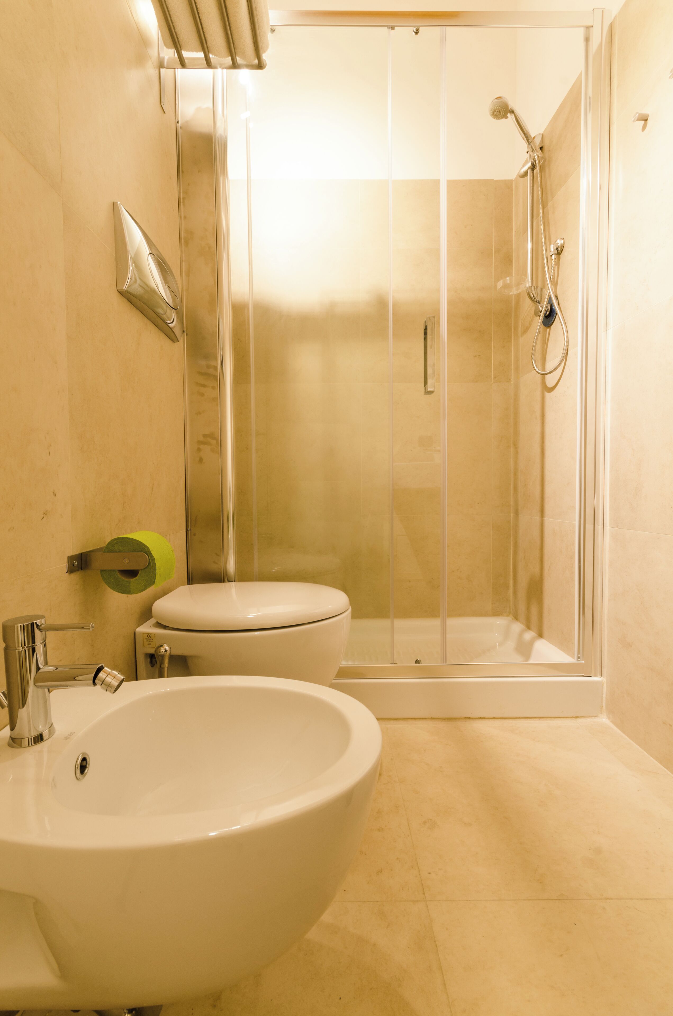 A bathroom with a sink, toilet, and a glass-enclosed shower area.