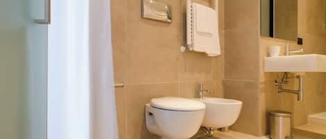 A modern bathroom with a shower, two sinks, a towel rack, and a mirror.