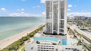 A high-rise hotel with a pool, beachfront view, and a marina. - Luxurious 2BD Condo with Direct Ocean Views & Resort Pool - Apartment (Sunny Isles Beach)