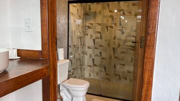 A bathroom with a toilet, a sink, and a shower enclosure.