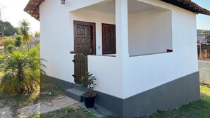A small, single-story house with a tiled roof, a wooden door, and a small porch area. - Pousada Villa Salgueiro (Ouro Preto)