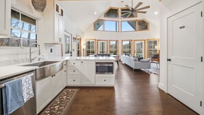 A spacious kitchen with a large island, white cabinetry, and a wooden ceiling. - Creeks n' Peaks - Ellijay, GA (Ellijay)