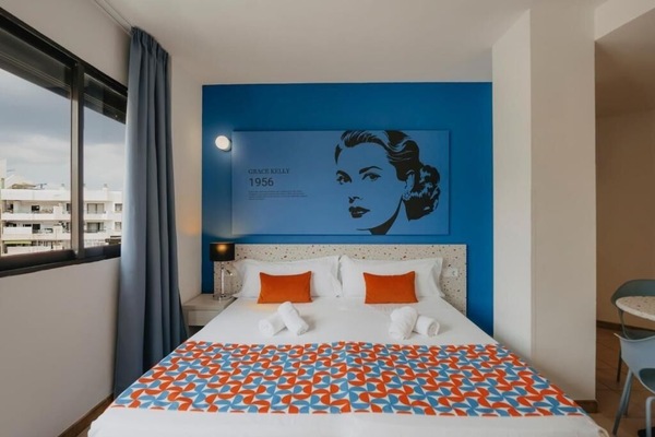 Unwind in crisp linens beneath bold, playful designer artwork.
