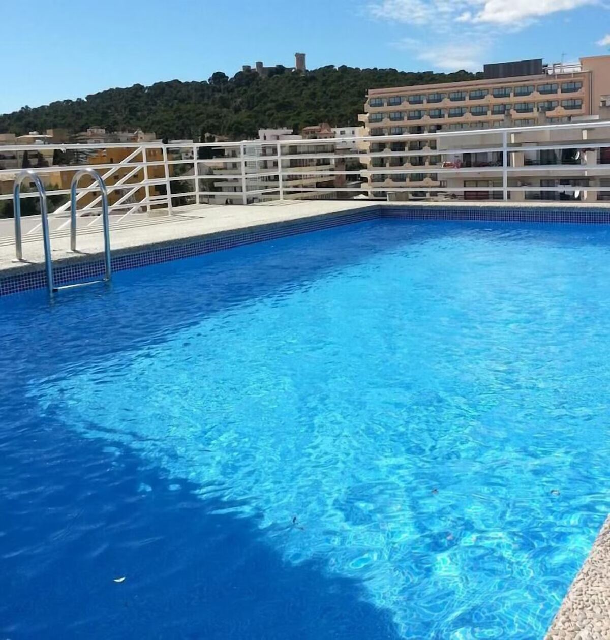 Swim laps in sparkling blue water with a scenic backdrop.