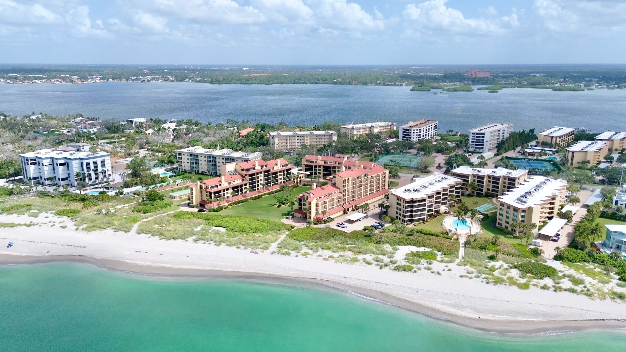 A coastal resort with beachfront villas, a swimming pool, and a view of the ocean.