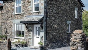 A stone building with a gabled roof, a front door, and a small porch area. - Bracken House - Luxury design 3 bed in Windermere (Windermere)