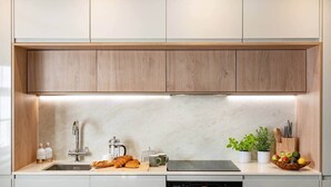 A modern kitchen with wooden cabinets, a stainless steel sink, a coffee maker, and a microwave. - Bracken House - Luxury design 3 bed in Windermere (Windermere)
