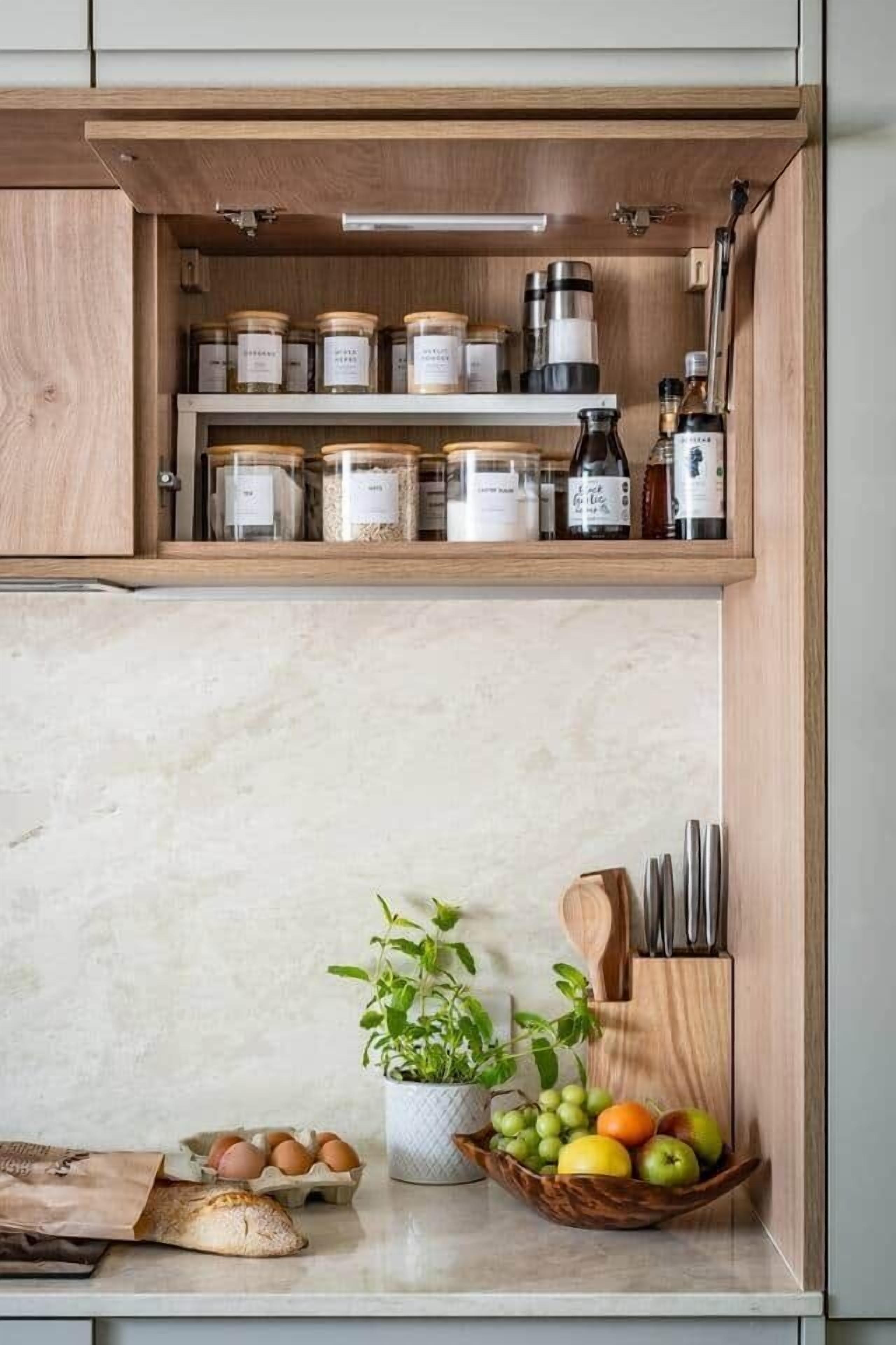 Een keuken met houten kastjes, een marmeren aanrecht, een plant, een schaal met fruit, eieren en een brood.