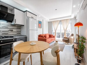 Un moderno appartamento con cucina, zona pranzo e soggiorno.