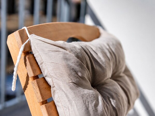 A wooden chair with a beige cushion. - Maxihomes Bliss (Antalya)