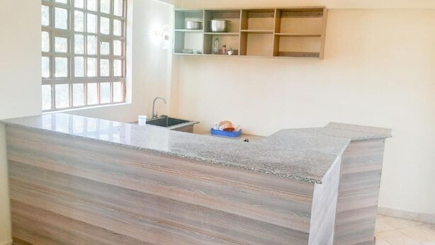A kitchen with a large island, a window, and built-in shelves.