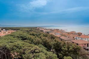 A coastal residential area with terraced houses, dense greenery, and a clear view of the sea. - Hotiday Cecina Mare (Cecina)