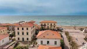 Eine Küstenstadt mit Häusern, deren Dächer mit roten Ziegeln gedeckt sind, und einem Strand im Hintergrund.
