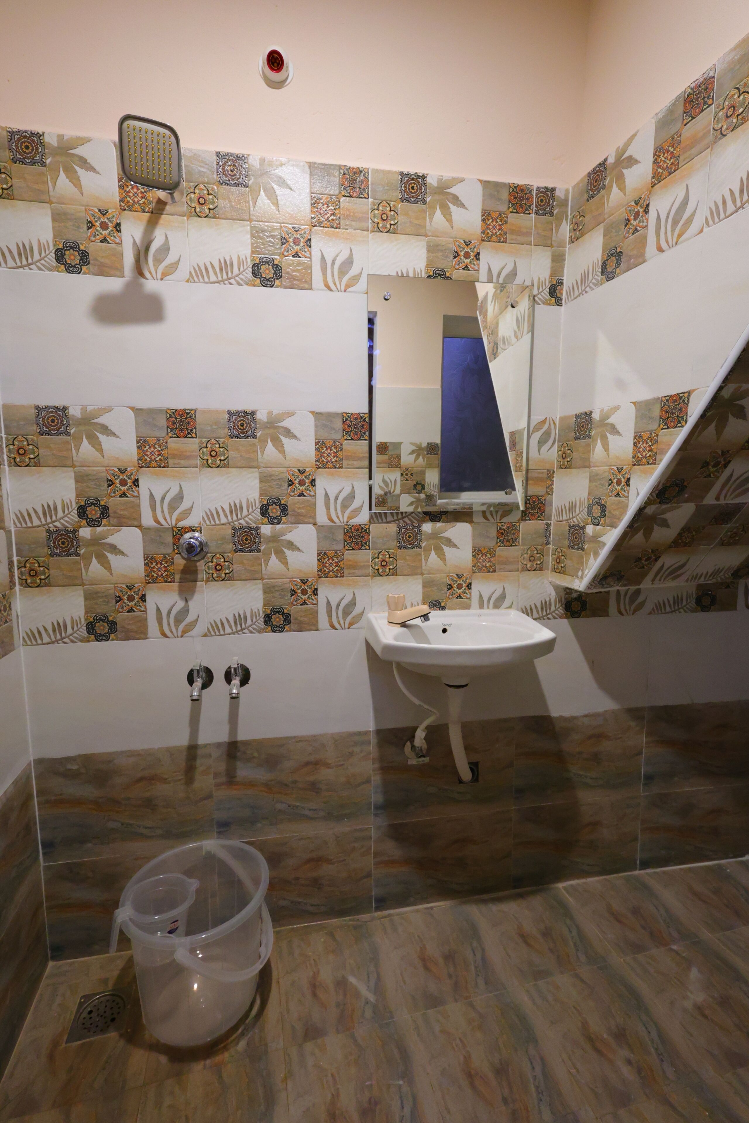 A bathroom with a sink, mirror, shower, and decorative tiles.