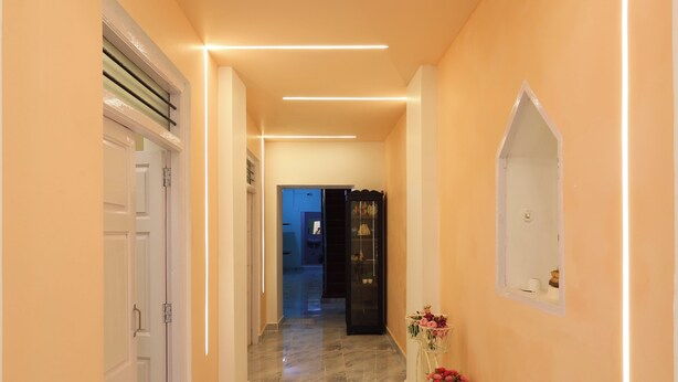 A hallway with a marble floor, white doors, and a black cabinet with glass doors. - Nautical Escape Homestay - Pondicherry (Puducherry)