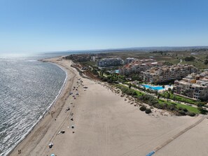 A coastal resort with a beach, swimming pool, and residential buildings. - Apartment 'Albatros' with Shared Pool, Private Terrace and Wi-Fi (Ayamonte)